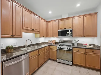 a kitchen with stainless steel appliances granite countertop white cabinets a sink and dishwasher