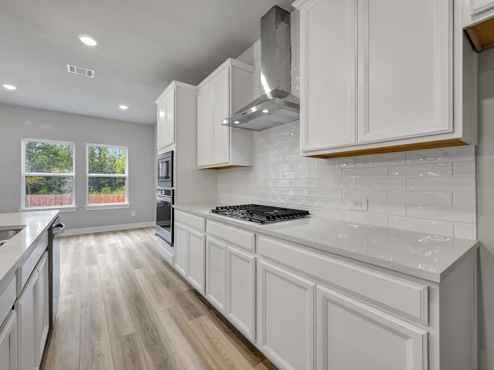 1645 Hopson Ranch Drive Conroe, TX 77301 - Photo 5 of 33 a kitchen with stainless steel appliances granite countertop a sink a stove and a wooden floors