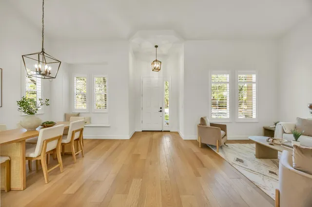 a view of kitchen with stainless steel appliances granite countertop dining table chairs sink and cabinets