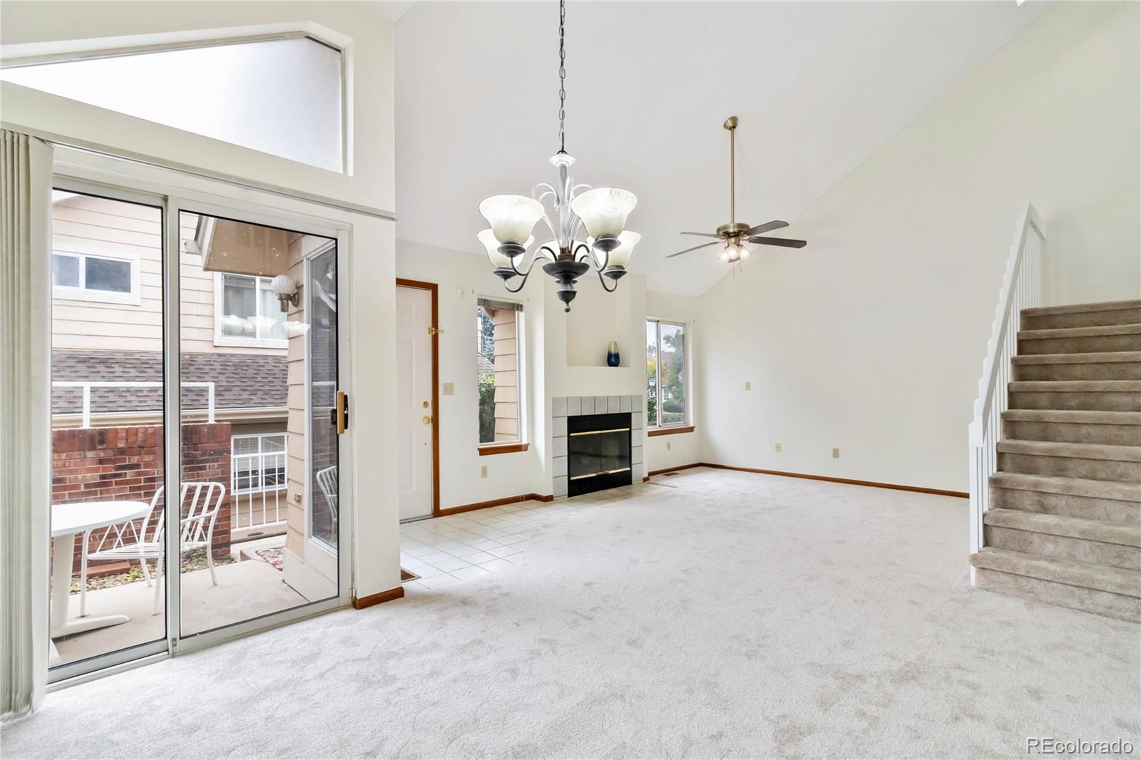a view of a livingroom with a chandelier fan and a fireplace