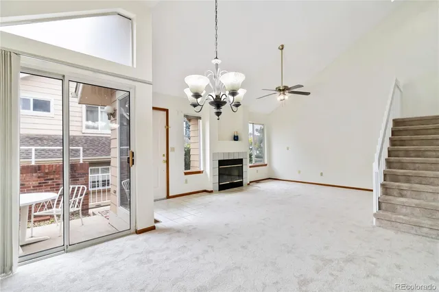 a view of a livingroom with a chandelier fan and a fireplace