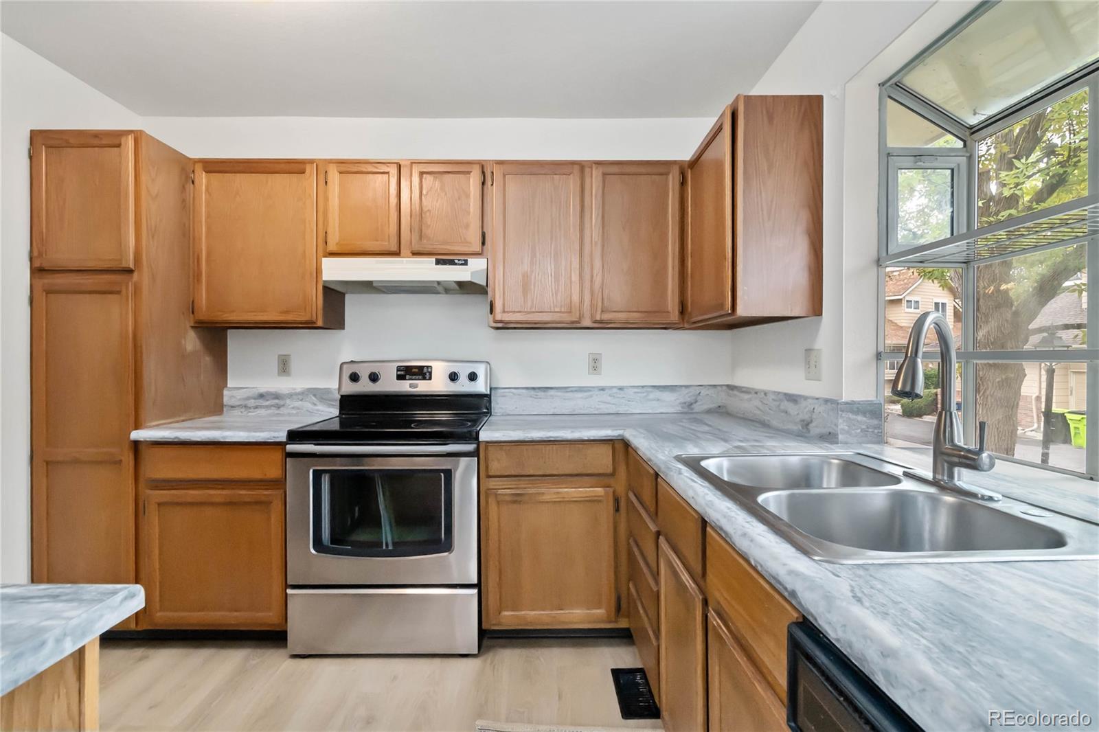 2136 South Scranton Way Aurora, CO 80014 - Photo 6 of 22 a kitchen with granite countertop a sink stove and cabinets