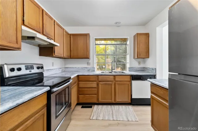 a kitchen with stainless steel appliances granite countertop a stove a sink and a microwave