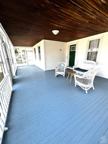 a balcony with furniture and wooden floor