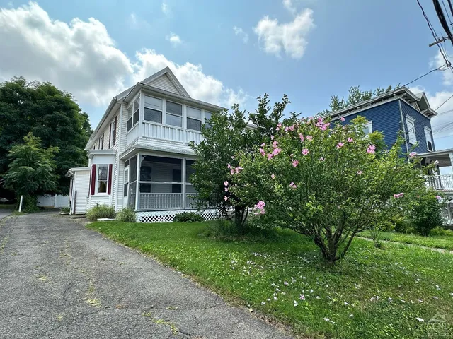 a front view of a house with a garden and plants