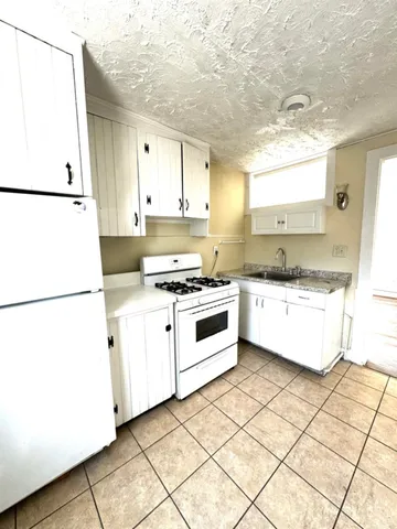 a kitchen with white cabinets and white appliances