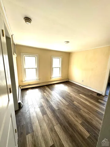 wooden floor in an empty room with a window