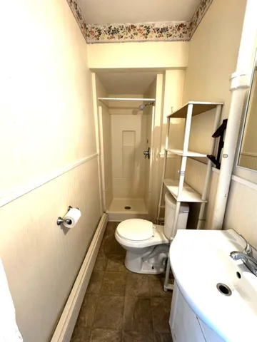 a bathroom with a sink a toilet and shower