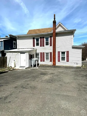 a front view of a house with a garden and parking space