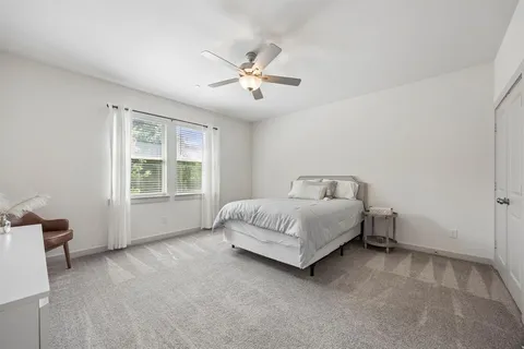 a spacious bedroom with a bed and a window