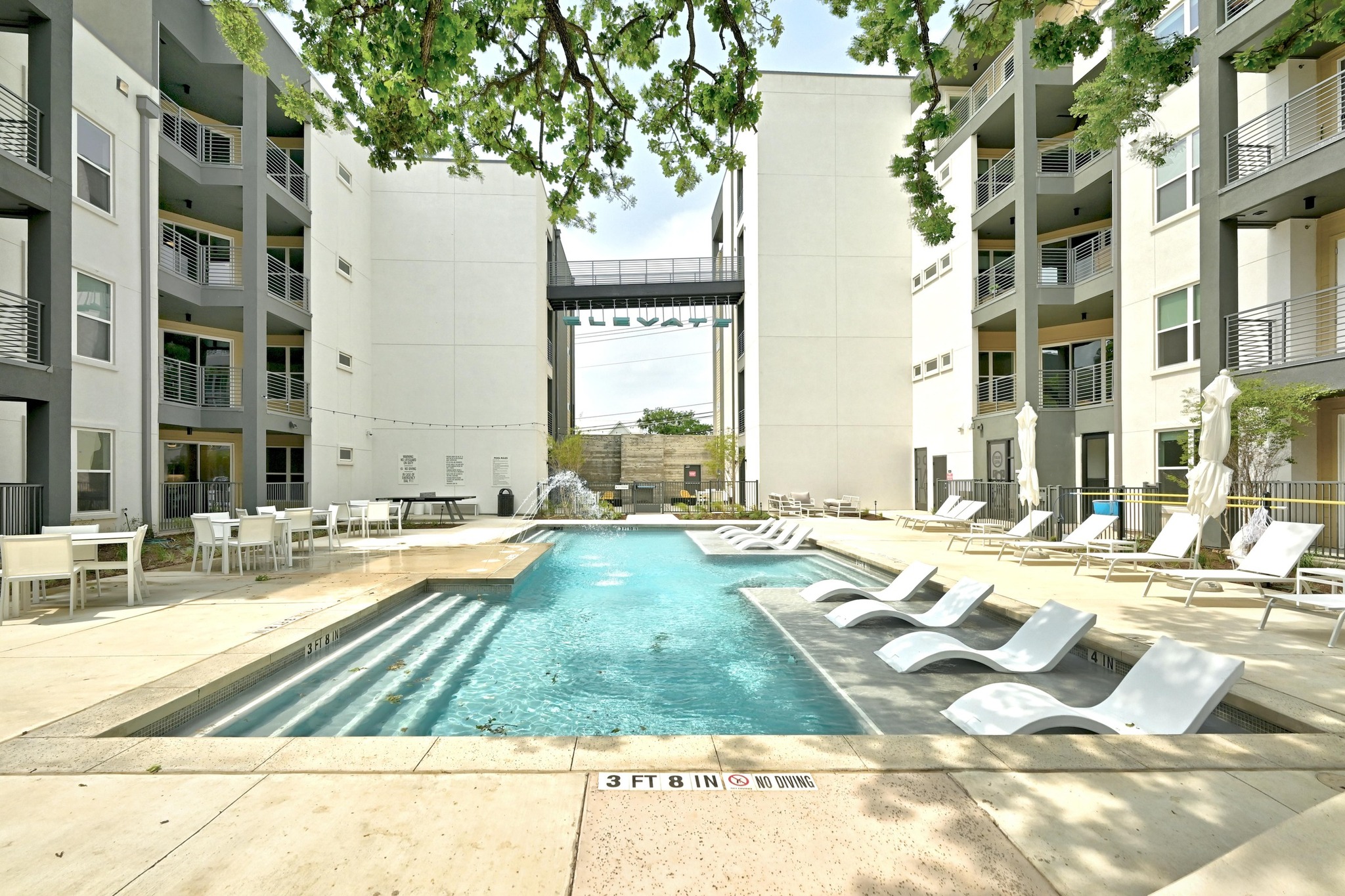 4801 Springdale Road, Unit 2301 Austin, TX 78723 - Photo 27 of 36 A sparkling pool with in-water lounge seating forms the heart of this vibrant community recreation area.
