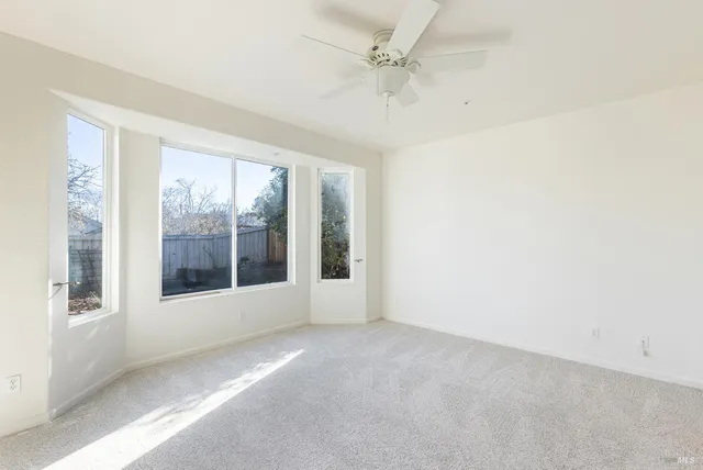 an empty room with a ceiling fan and a bathroom