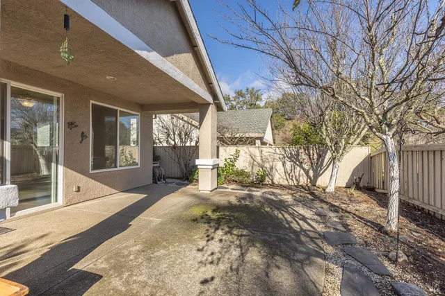 a view of a backyard with table and chairs and wooden fence