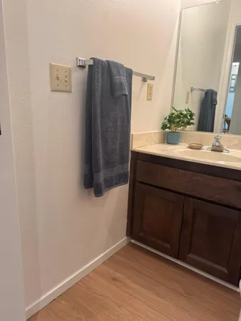 a bathroom with a granite countertop toilet sink and mirror