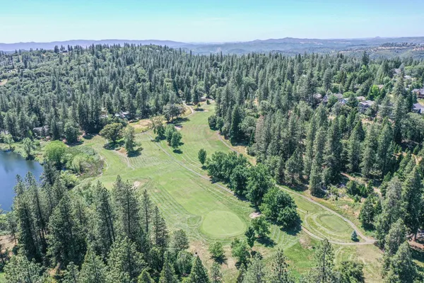 an aerial view of a house with a yard and lake view