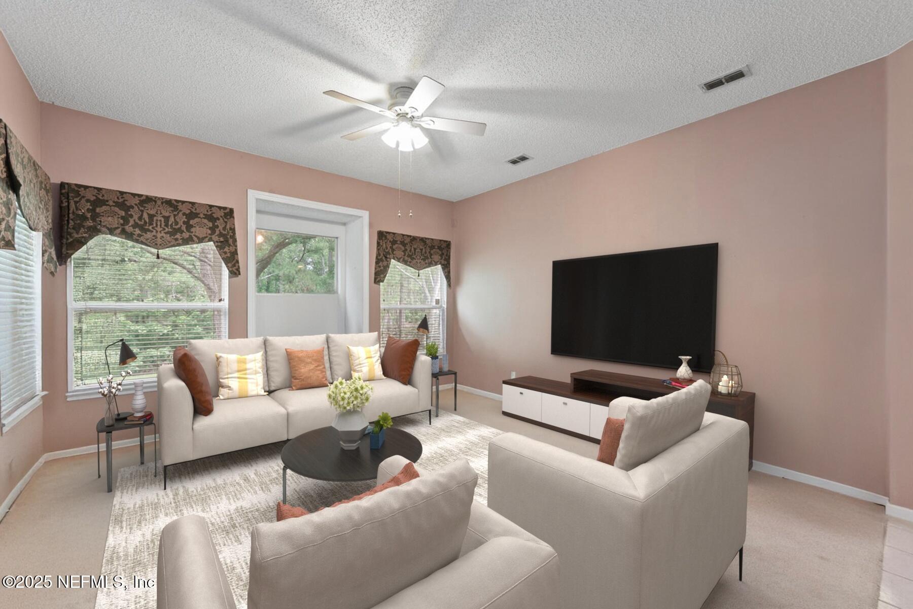 4219 Woodley Creek Road Jacksonville, FL 32218 - Photo 12 of 28 a living room with furniture and a flat screen tv
