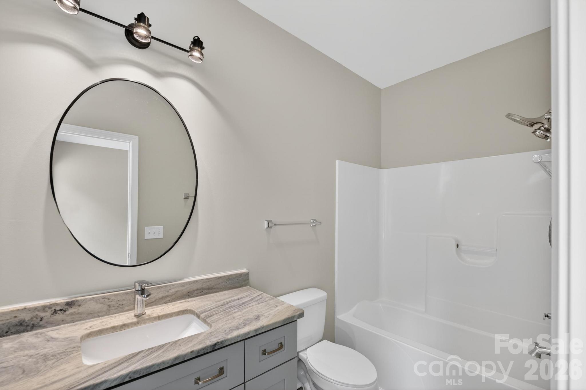 2119 South Road Morganton, NC 28655 - Photo 29 of 47 a bathroom with a granite countertop toilet a sink and a mirror