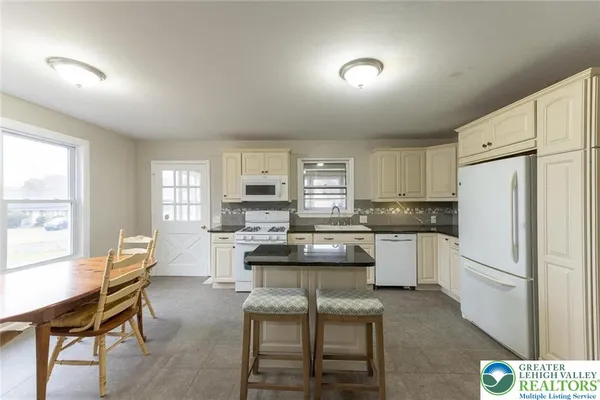 a kitchen with a refrigerator a table and chairs in it