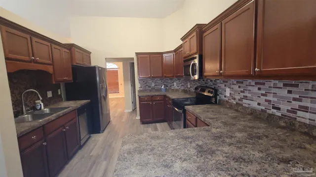 a kitchen with stainless steel appliances a sink cabinets and a refrigerator