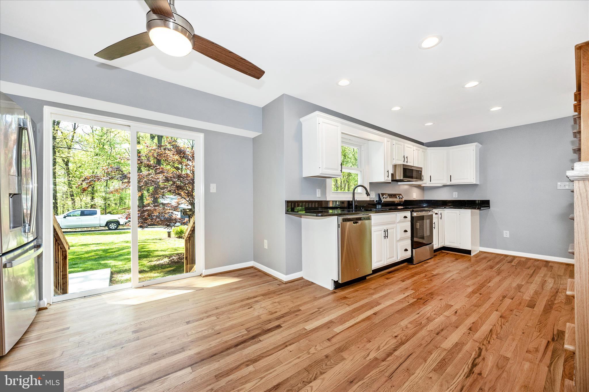 6518 Woodville Road Mount Airy, MD 21771 - Photo 14 of 53 a kitchen with stainless steel appliances granite countertop a stove top oven a sink with a dining table and chairs