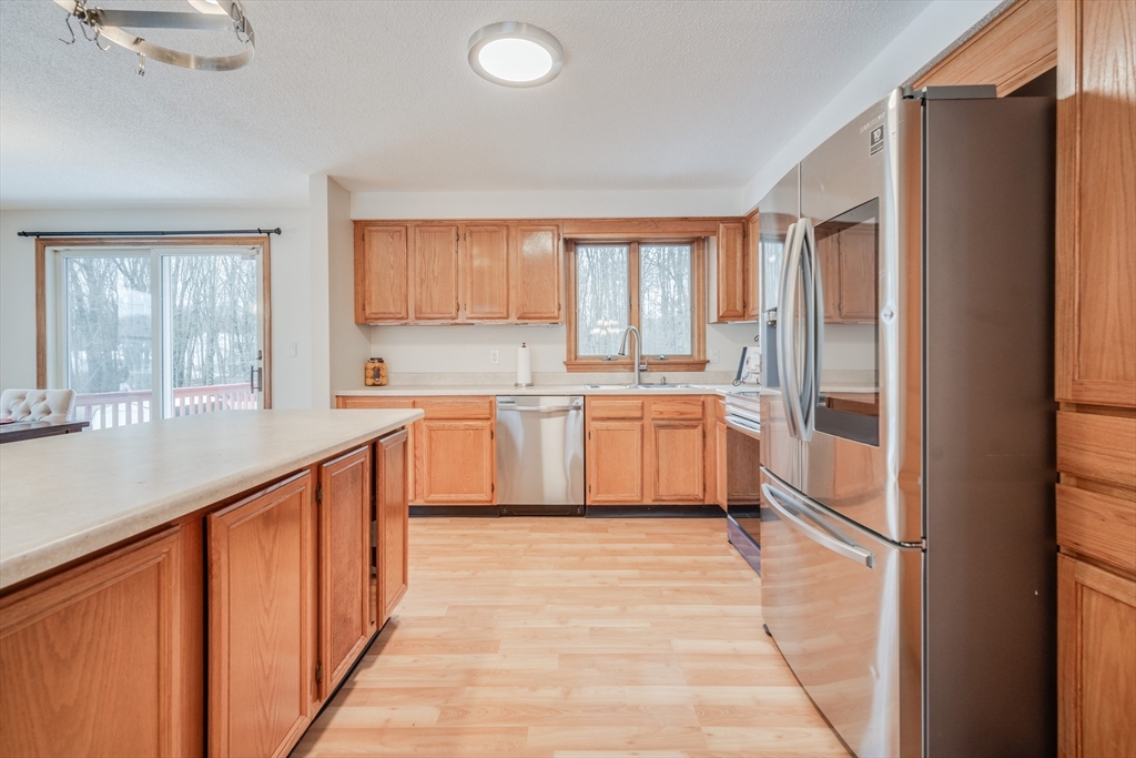 20 Middle Road Enfield, CT 06082 - Photo 5 of 29 a kitchen with stainless steel appliances granite countertop a refrigerator a sink dishwasher and white cabinets with wooden floor