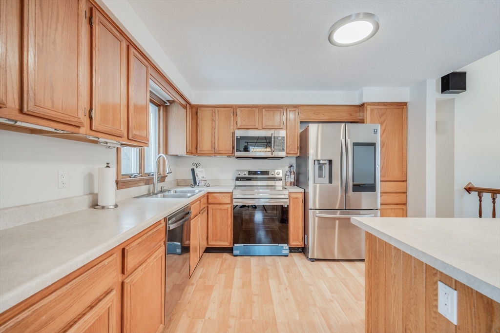 20 Middle Road Enfield, CT 06082 - Photo 6 of 29 a kitchen with stainless steel appliances granite countertop a refrigerator a sink dishwasher and a stove with wooden cabinets