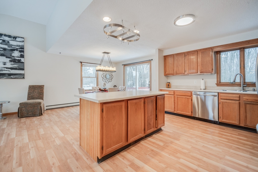 20 Middle Road Enfield, CT 06082 - Photo 7 of 29 a kitchen with stainless steel appliances granite countertop a white cabinets a sink a stove a dining table and chairs