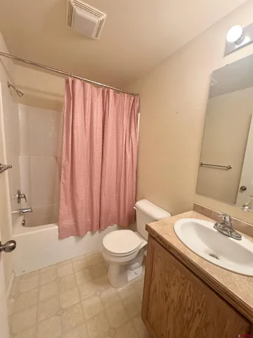 a bathroom with a sink a toilet and shower curtain