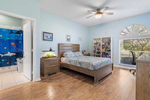 a bedroom with a bed dresser and a large window