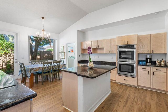 a kitchen with kitchen island granite countertop a stove a sink and a refrigerator