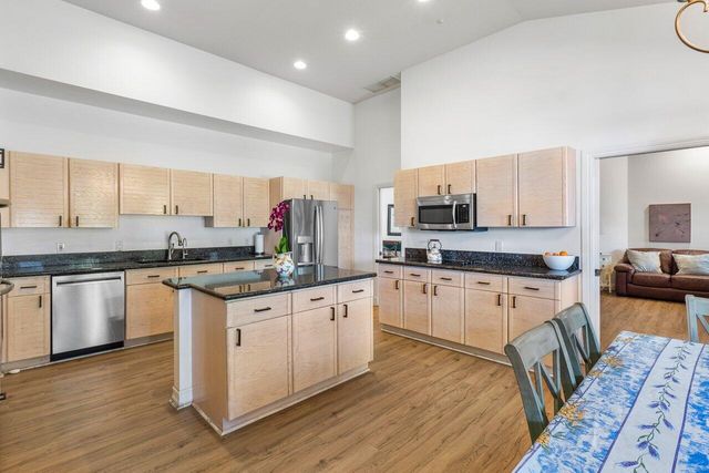 a kitchen with granite countertop white cabinets and wooden floor