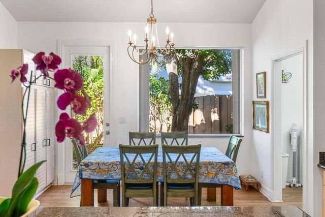a view of a dining room with furniture a chandelier and wooden floor
