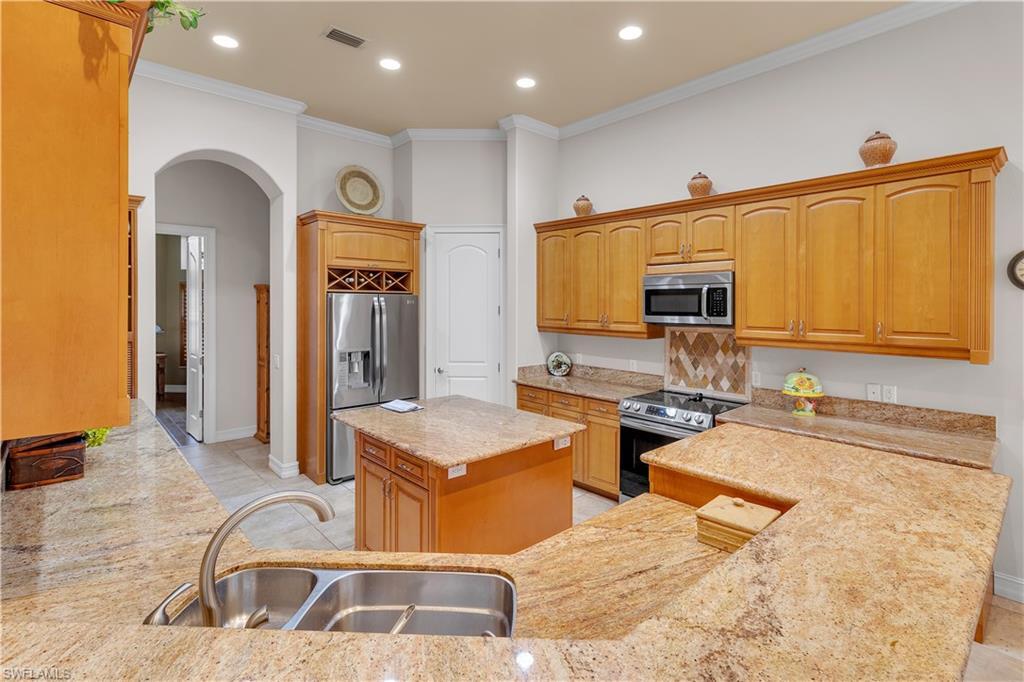 14600 Fritchey Road Naples, FL 34114 - Photo 11 of 44 a large kitchen with stainless steel appliances granite countertop a sink and cabinets