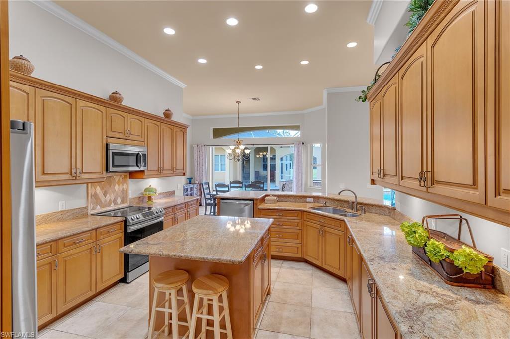 14600 Fritchey Road Naples, FL 34114 - Photo 12 of 44 a large kitchen with kitchen island granite countertop a sink and dishwasher with a dining table