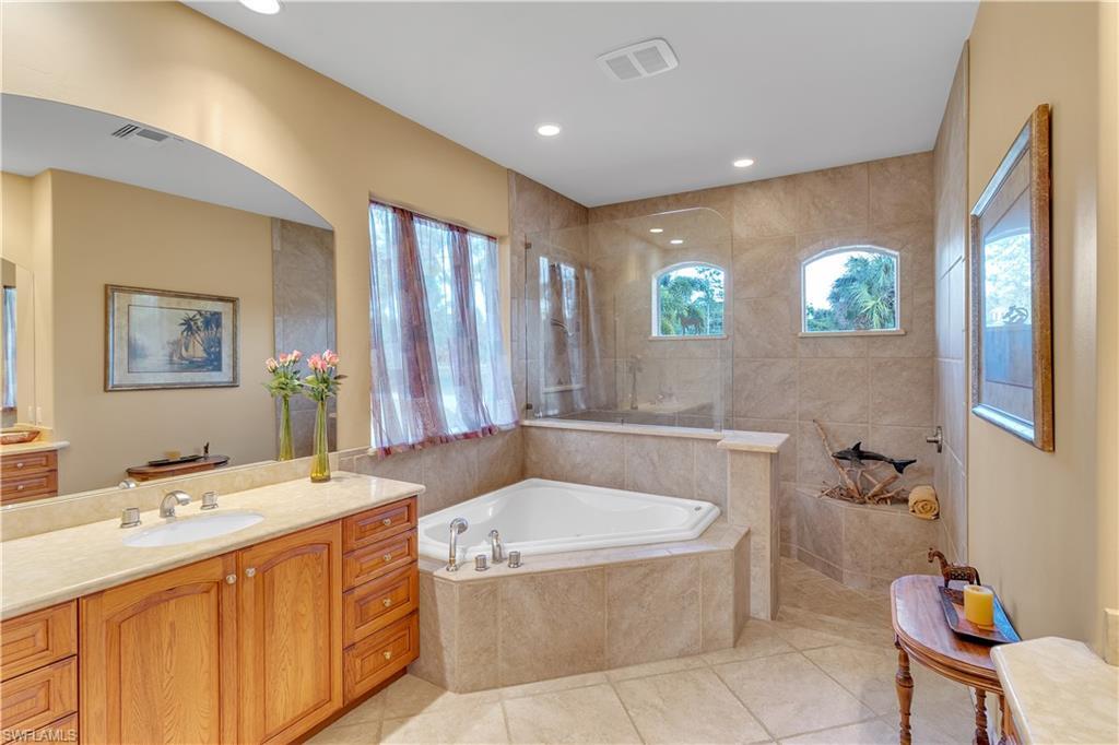 14600 Fritchey Road Naples, FL 34114 - Photo 15 of 44 a bathroom with a tub a sink and mirror