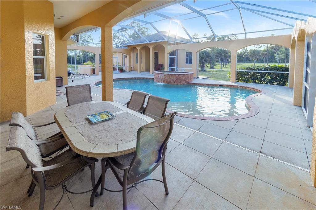 14600 Fritchey Road Naples, FL 34114 - Photo 19 of 44 a view of a dining room with furniture wooden floor and a rug