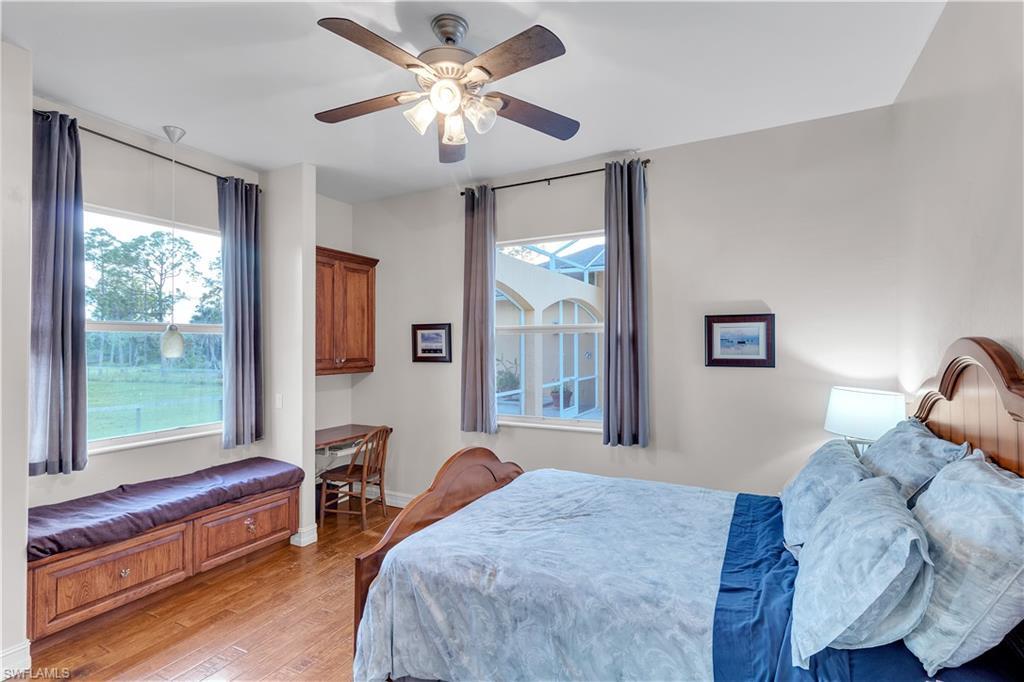 14600 Fritchey Road Naples, FL 34114 - Photo 22 of 44 a bedroom with a large bed and a chandelier