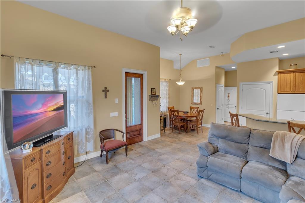 14600 Fritchey Road Naples, FL 34114 - Photo 28 of 44 a living room with furniture a flat screen tv and kitchen view