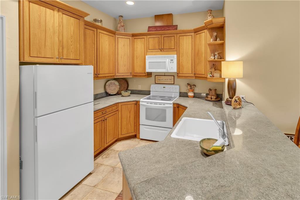 14600 Fritchey Road Naples, FL 34114 - Photo 29 of 44 a kitchen with a sink a stove and a refrigerator