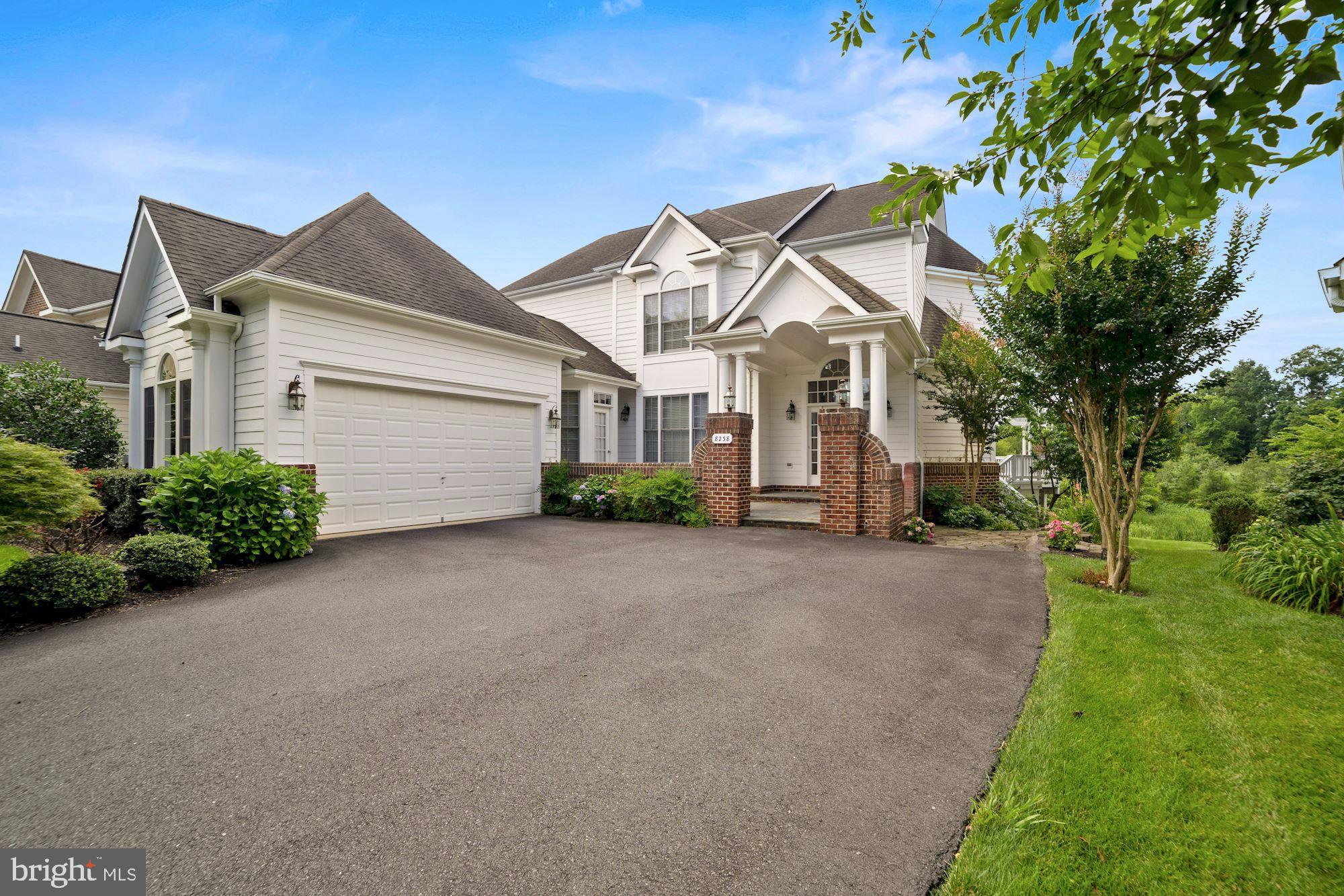 a view of a house with a small yard and a large tree