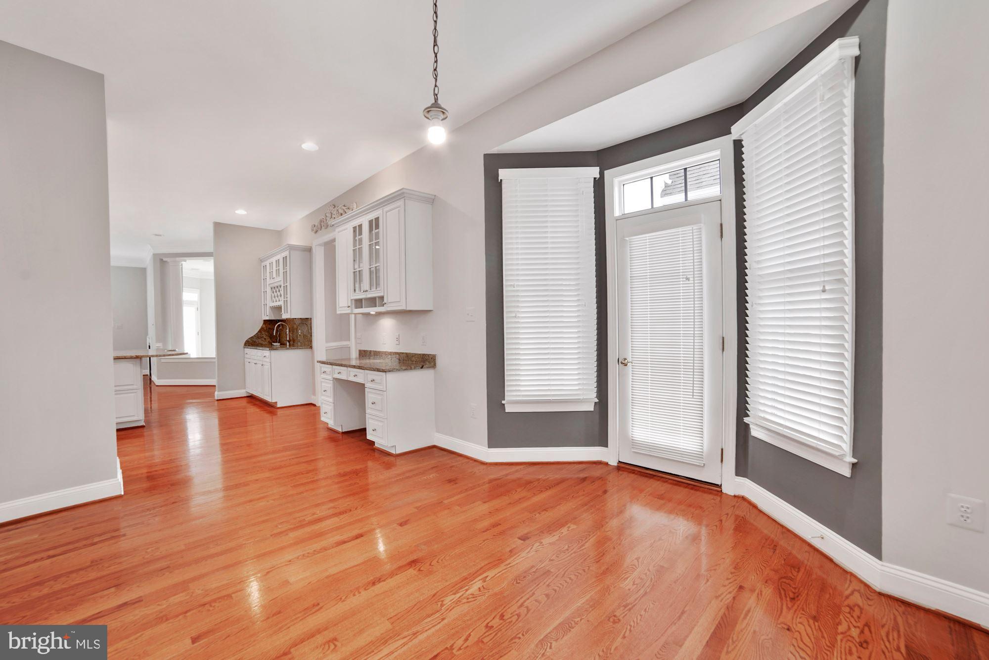 8238 Snead Loop Gainesville, VA 20155 - Photo 11 of 49 a view of empty room with wooden floor and kitchen view