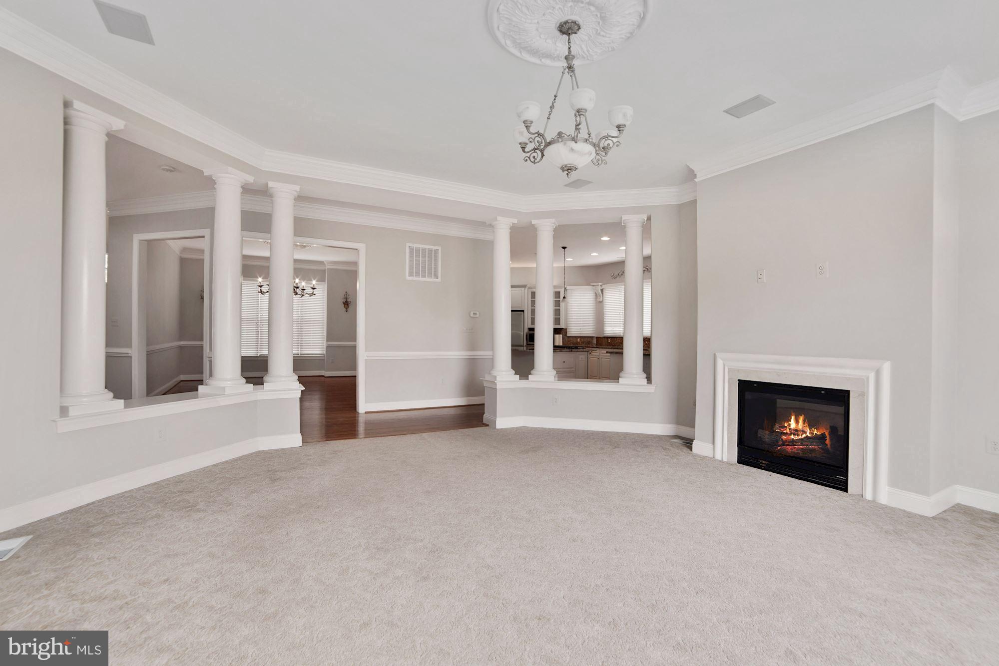 8238 Snead Loop Gainesville, VA 20155 - Photo 16 of 49 a view of a livingroom with a fireplace chandelier and windows