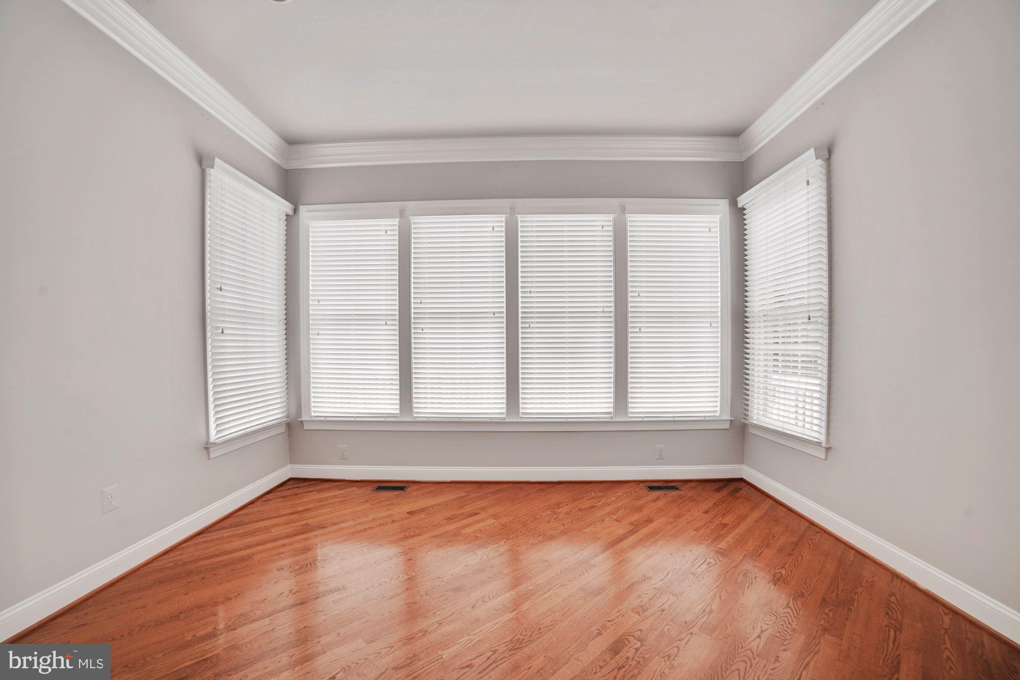 8238 Snead Loop Gainesville, VA 20155 - Photo 17 of 49 an empty room with wooden floor and windows