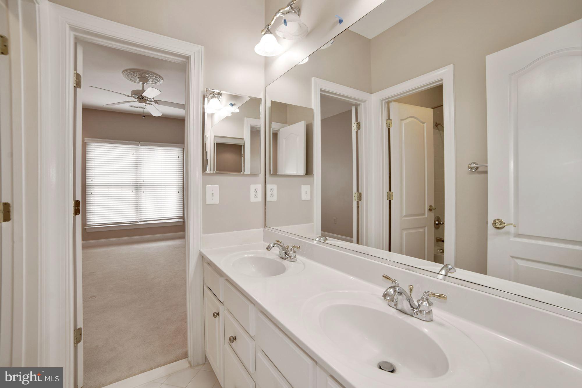 8238 Snead Loop Gainesville, VA 20155 - Photo 34 of 49 a bathroom with a double vanity sink and a mirror