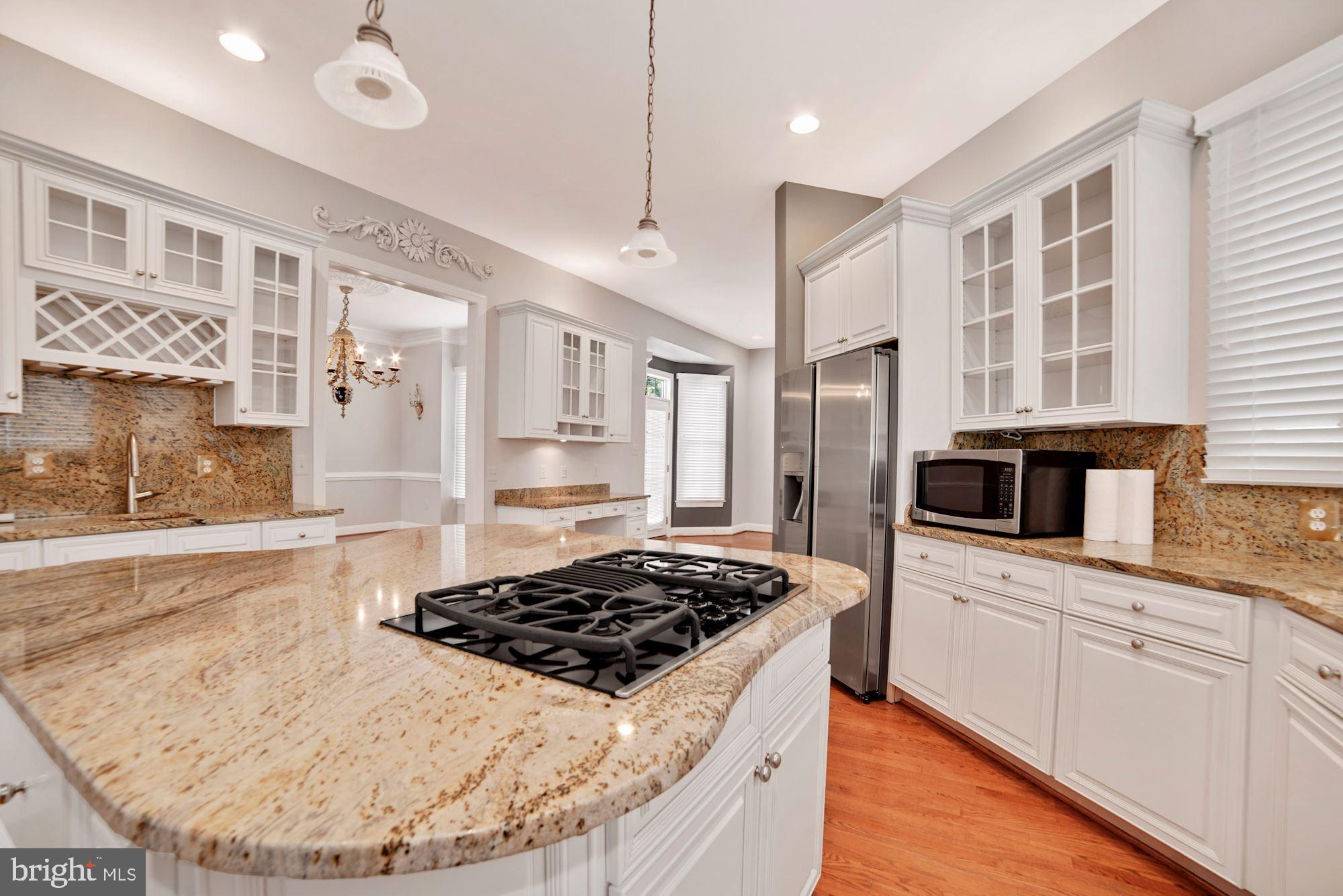 8238 Snead Loop Gainesville, VA 20155 - Photo 4 of 49 a kitchen with stainless steel appliances a stove a sink and a refrigerator