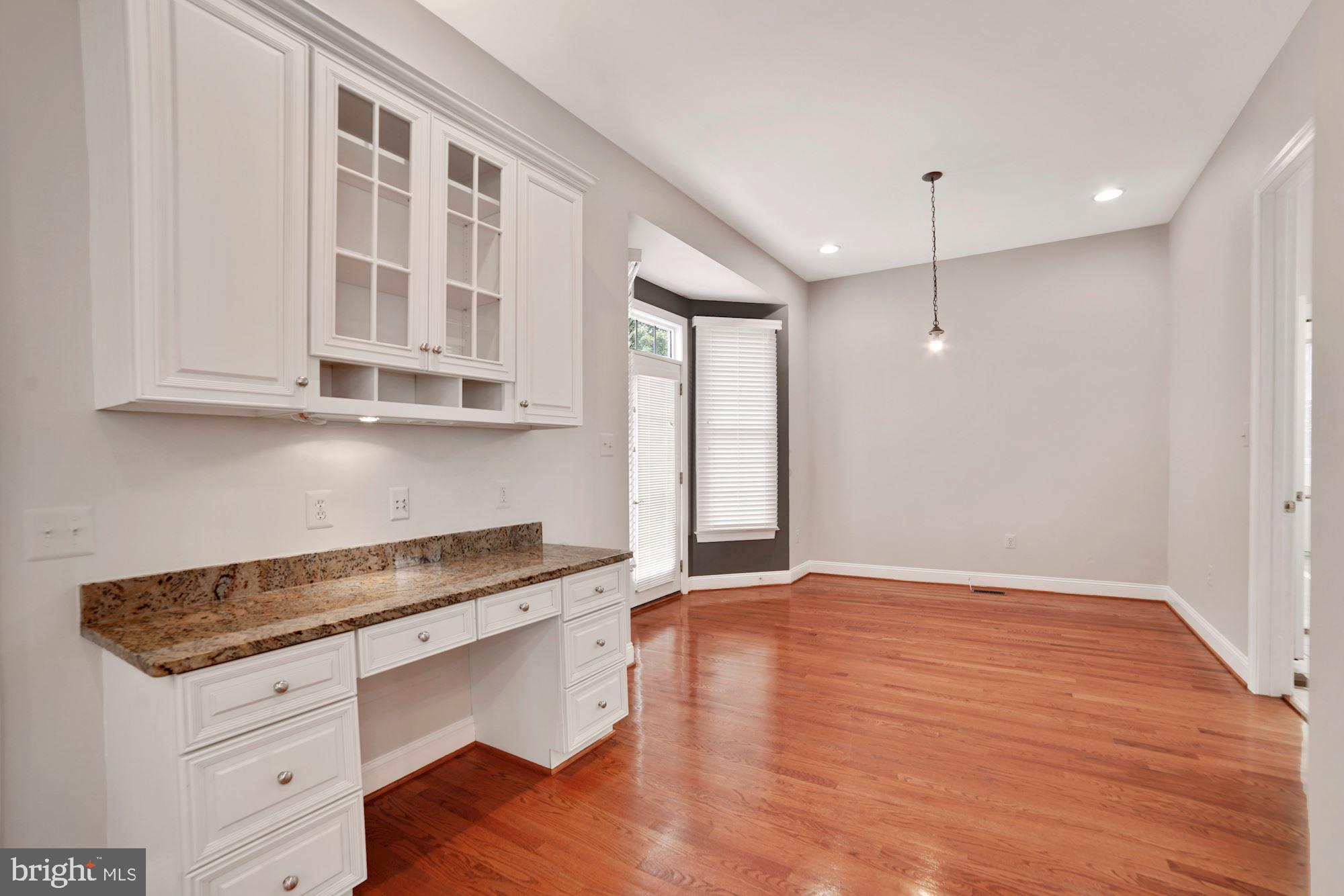 8238 Snead Loop Gainesville, VA 20155 - Photo 5 of 49 a kitchen with granite countertop a stove and a wooden floor