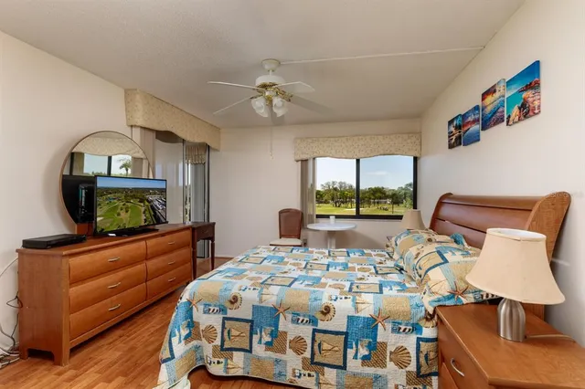a bedroom with a bed a large window and flat screen tv