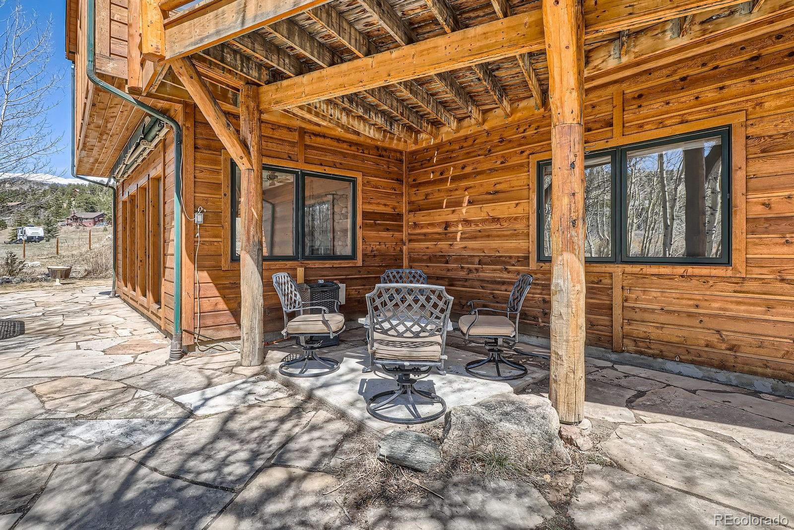 44 Forest Ridge Circle Bailey, CO 80421 - Photo 30 of 50 a view of a patio with table and chairs and wooden fence