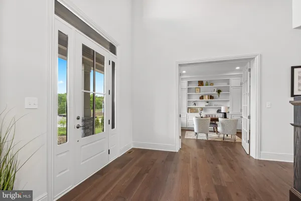 a view of a hallway with wooden floor and a living room
