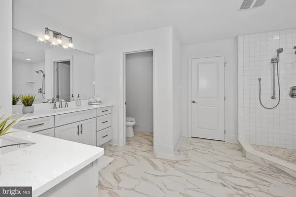 a spacious bathroom with a shower sink and mirror